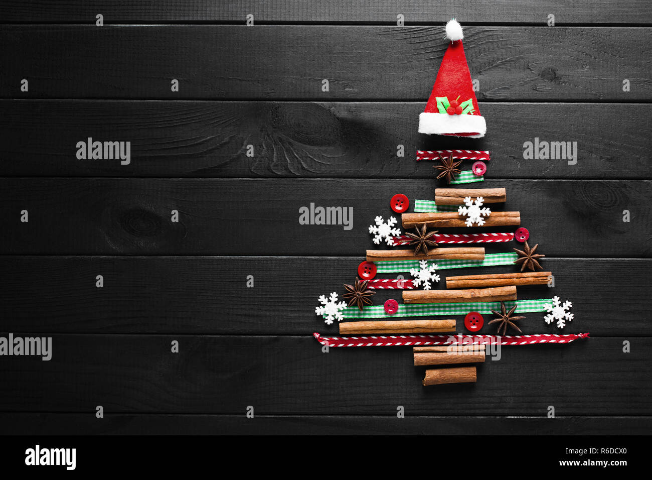 Arborescence constituée de décoration de Noël en bois sur fond sombre. Carte de nouvelle année Banque D'Images