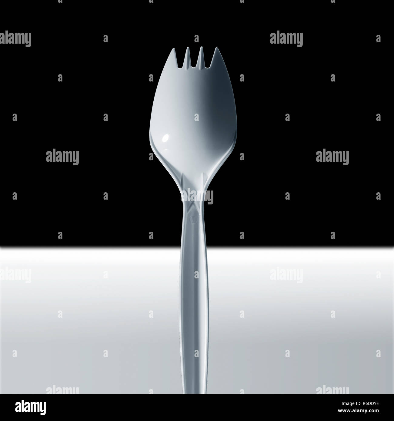 Image recadrée de fourchette en plastique jetables, surface blanche, fond noir Banque D'Images