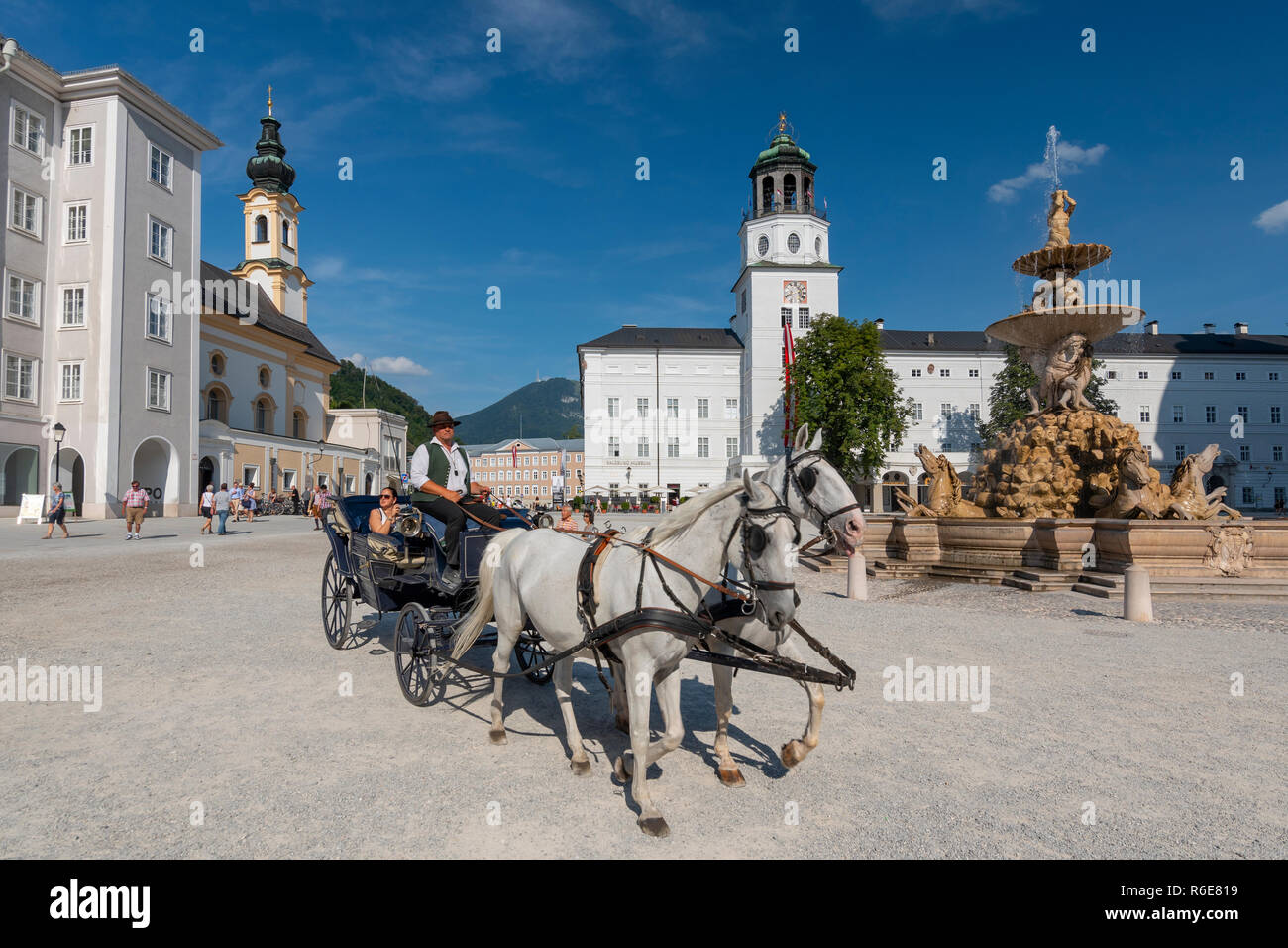 Les touristes Ride Une calèche devant Residenzbrunnen Fontaine et Église St Michaels sur place de la résidence, Salzbourg, Autriche Banque D'Images
