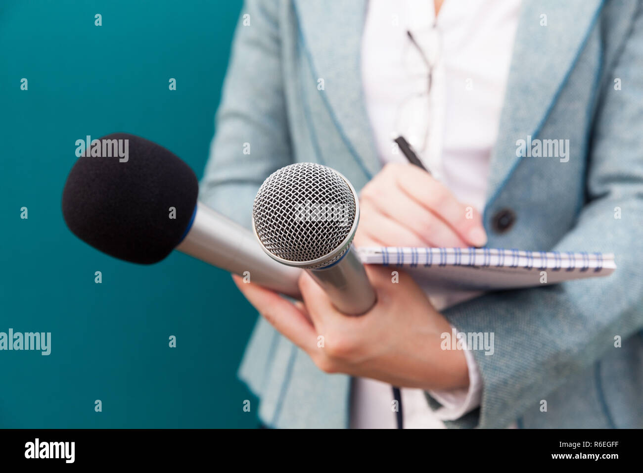 Femme journaliste à la conférence de presse, la rédaction de notes, holding microphone Banque D'Images