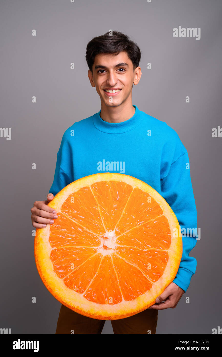 Young woman holding persan grande tranche de fruits orange Banque D'Images