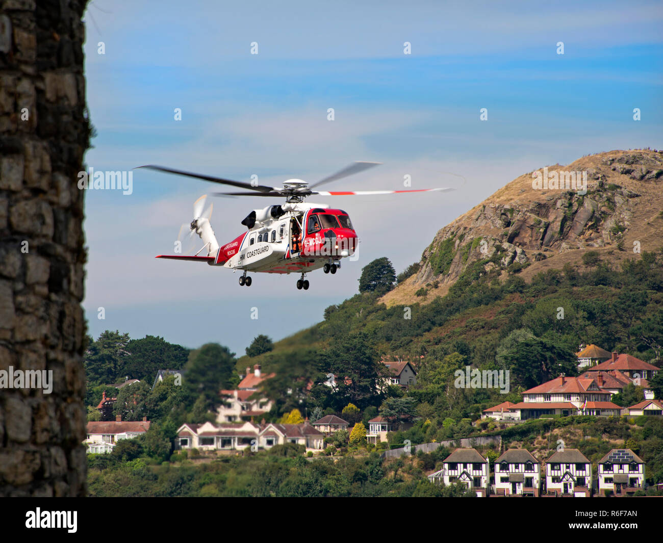 Vue horizontale d'un garde-côtes HM hélicoptère volant dans le ciel. Banque D'Images