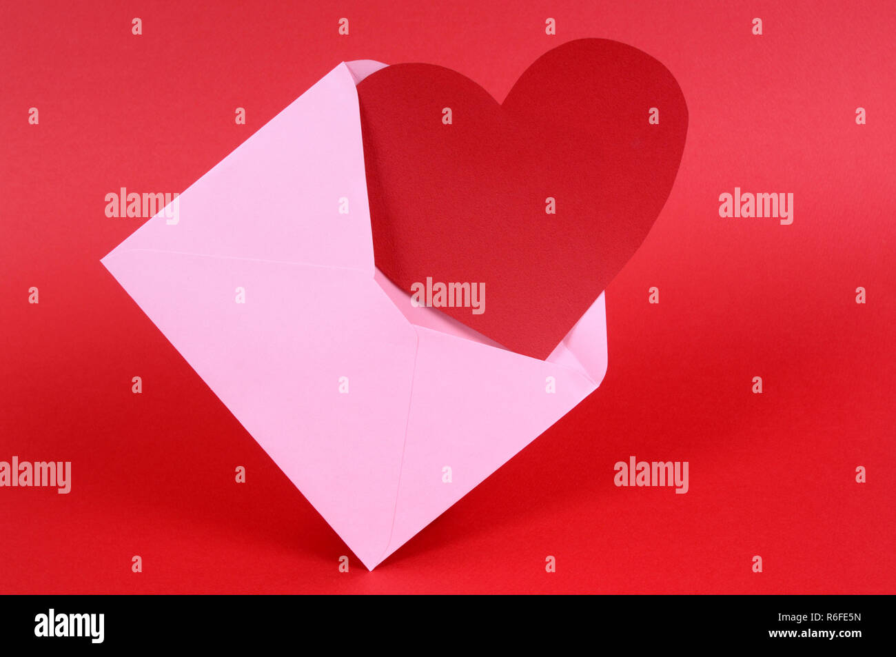 Carte de la Saint-Valentin en forme de coeur blanc avec enveloppe rose. Banque D'Images