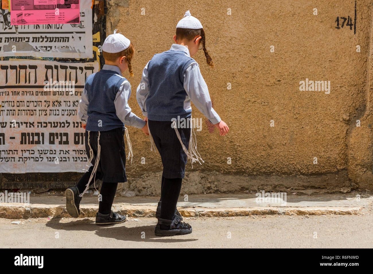Les garçons juifs ultra orthodoxe en marchant dans la rue À Mea Shearim communauté juive orthodoxe de Jérusalem, Israël Trimestre Banque D'Images