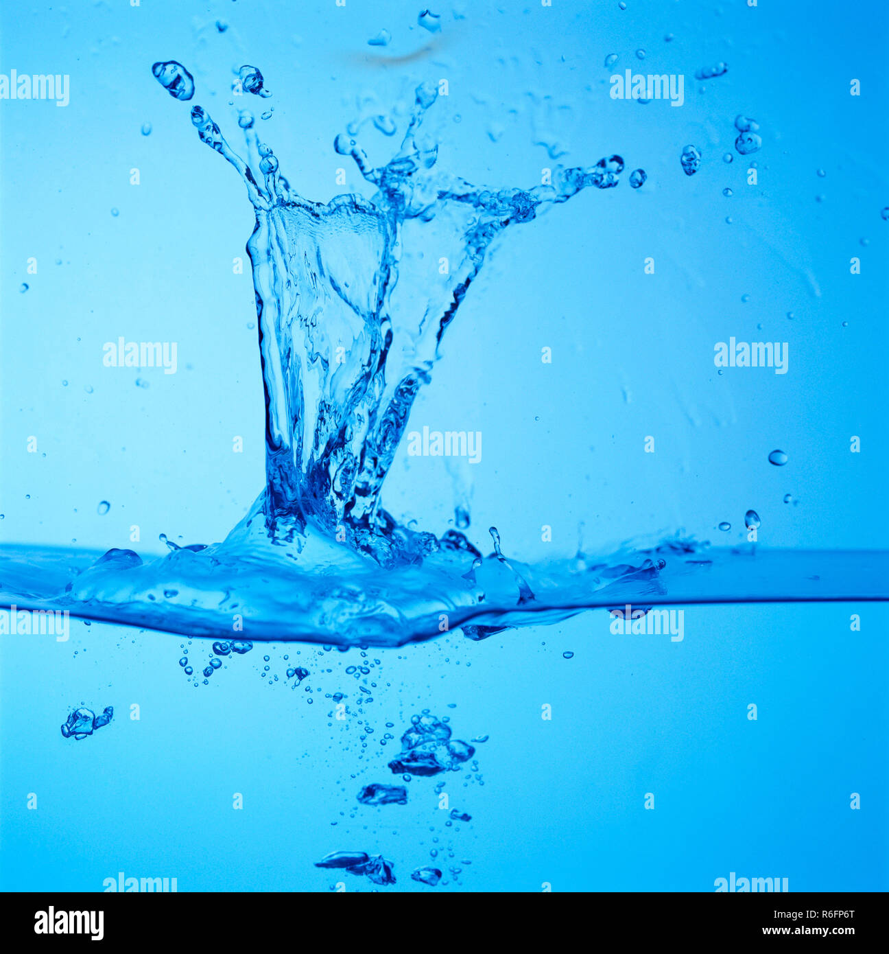 Concept, goutte d'eau splash avec fond bleu Banque D'Images