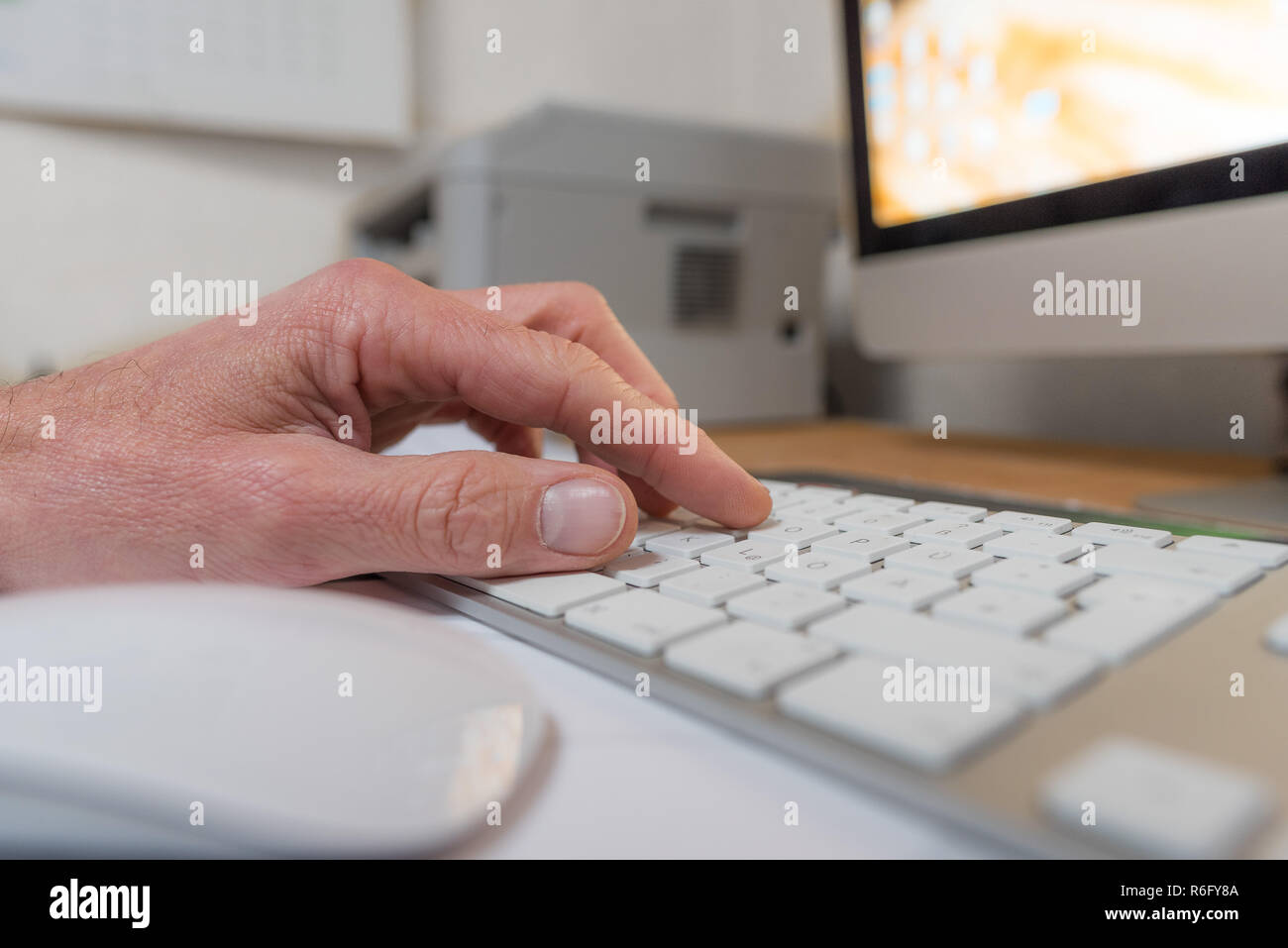 Main sur un clavier à l'écran et de l'imprimante en arrière-plan Banque D'Images