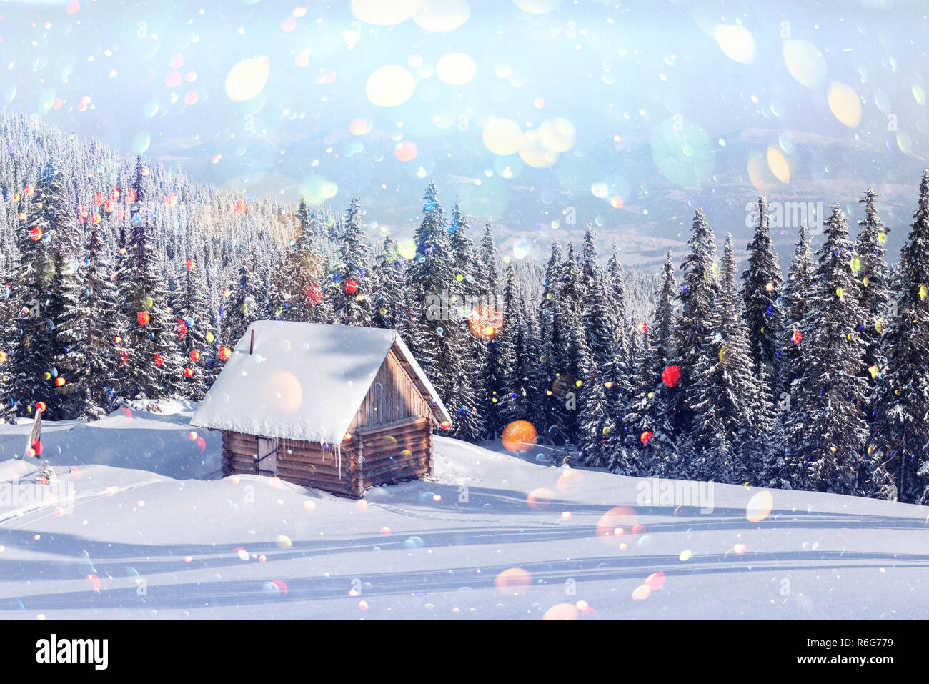 Paysage d'hiver fantastique avec maison en bois dans les montagnes enneigées. Carte postale de vacances de Noël collage. Lumière effet bokeh DOF post-traitement Banque D'Images