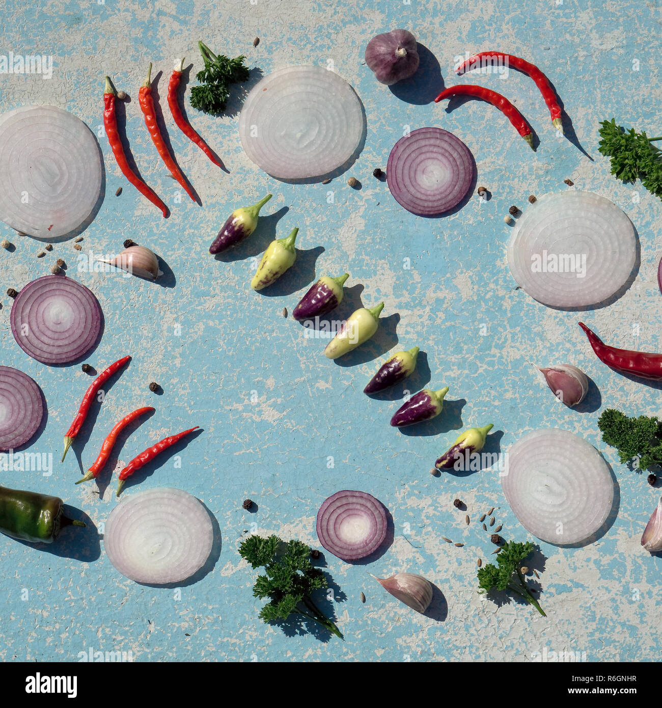 Des légumes frais blanc .et l'oignon rouge, rouge et vert clile poivre et d'épices sur la table en bois bleu au jardin en journée d'été. copie espace, top v Banque D'Images