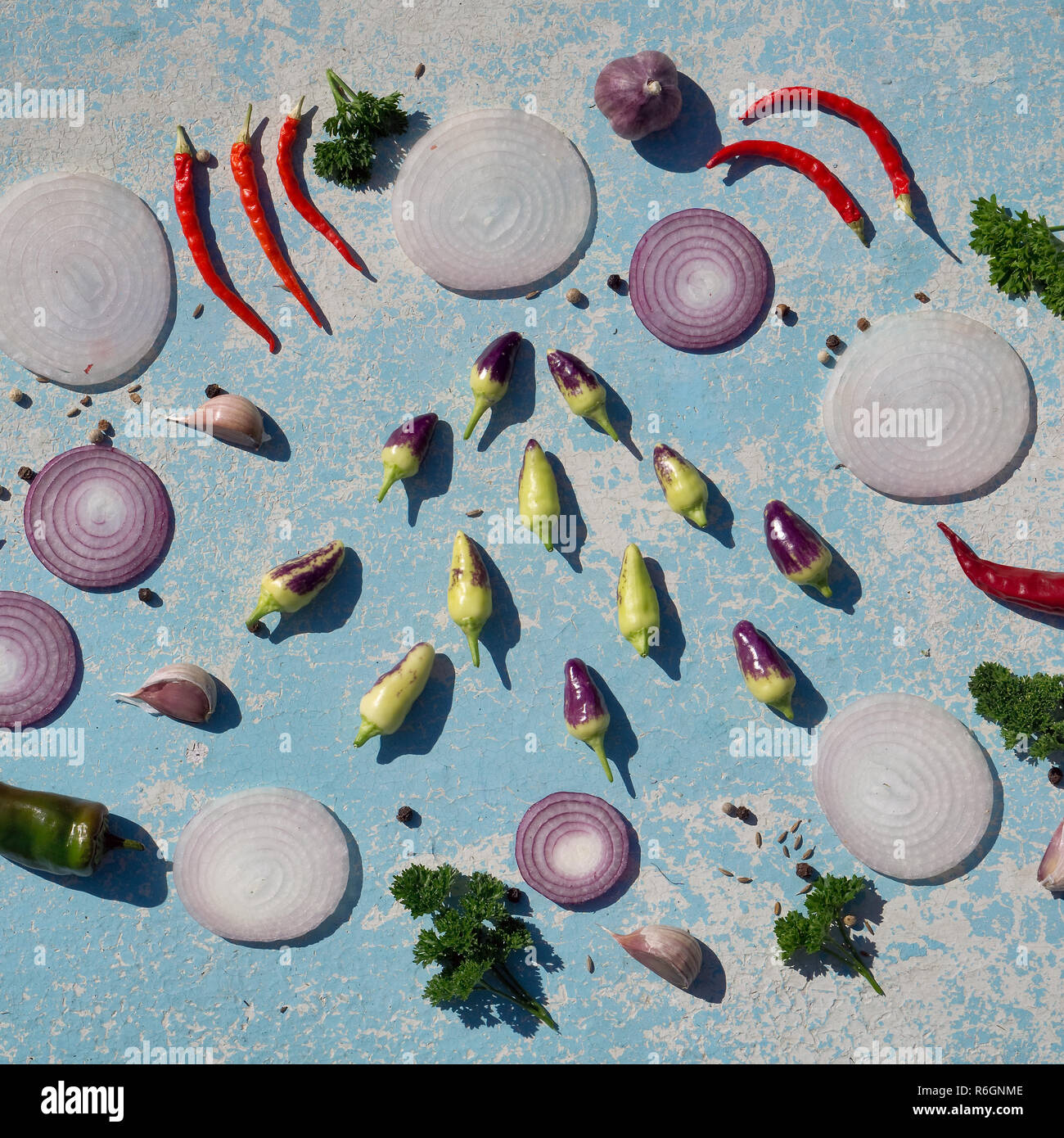 Des légumes frais blanc .et l'oignon rouge, rouge et vert clile poivre et d'épices sur la table en bois bleu au jardin en journée d'été. copie espace, top v Banque D'Images