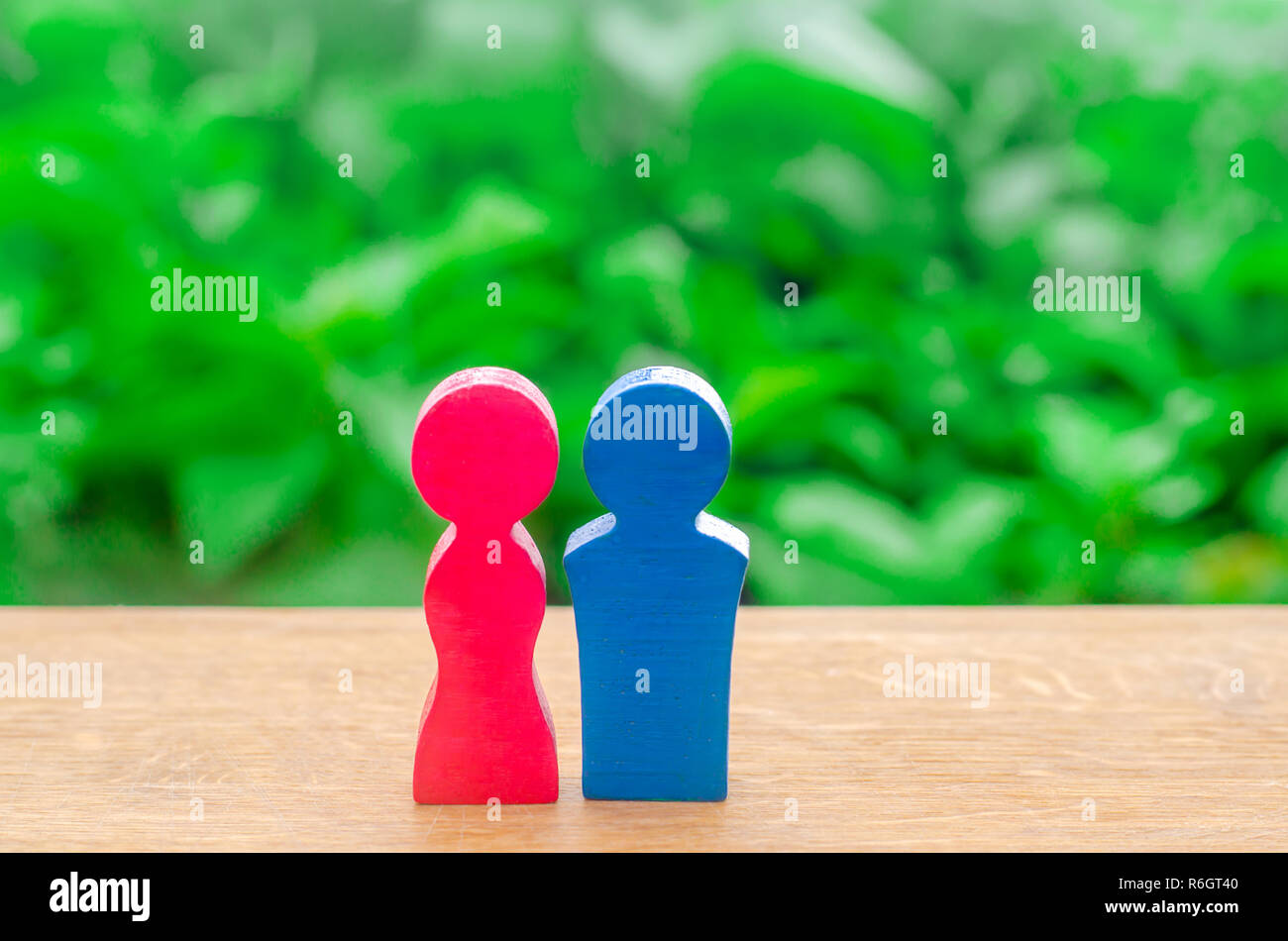 La figure en bois d'un homme et une femme sur un arrière-plan flou vert. Concept de l'amour, amoureux, l'amour. Les relations entre les sexes. Le minimalisme. Mariage et weddi Banque D'Images