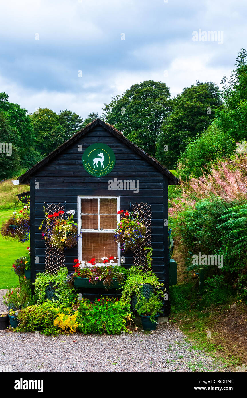 La jolie cabane de greenkeeper combinée en bois et billetterie décoré de fleurs et de paniers suspendus et entouré d'arbres majestueux Banque D'Images