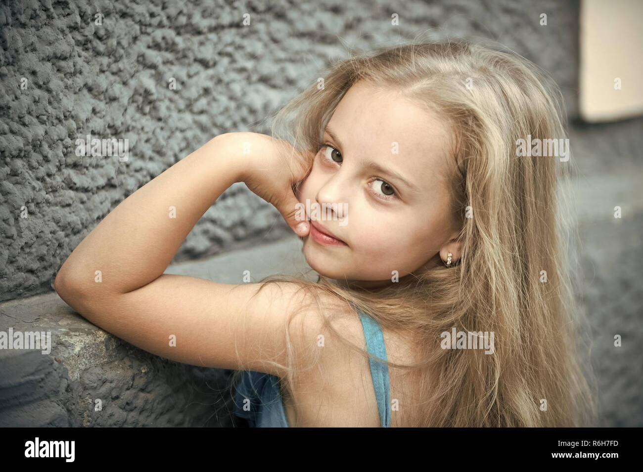 Petit Bebe Fille Ou Enfant Mignon Visage Adorable Avec De Longs Cheveux Blonds Et A L Ete En Plein Air Sur Fond De Mur De Pierre Photo Stock Alamy