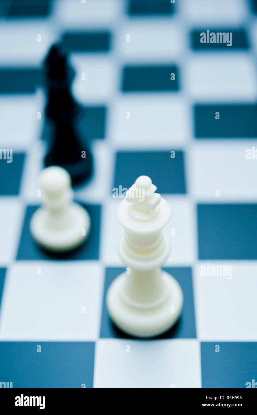 Grossissement des pièces d'échecs noires sur un échiquier noir et blanc avec mise au point sélective et profondeur de champ peu importante. Banque D'Images