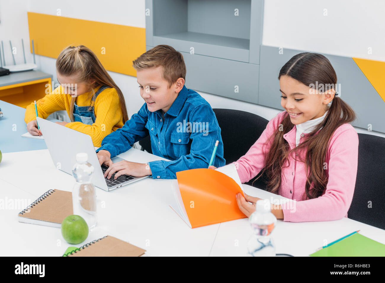 Heureux écoliers assis à 24 dans la classe de la tige Banque D'Images