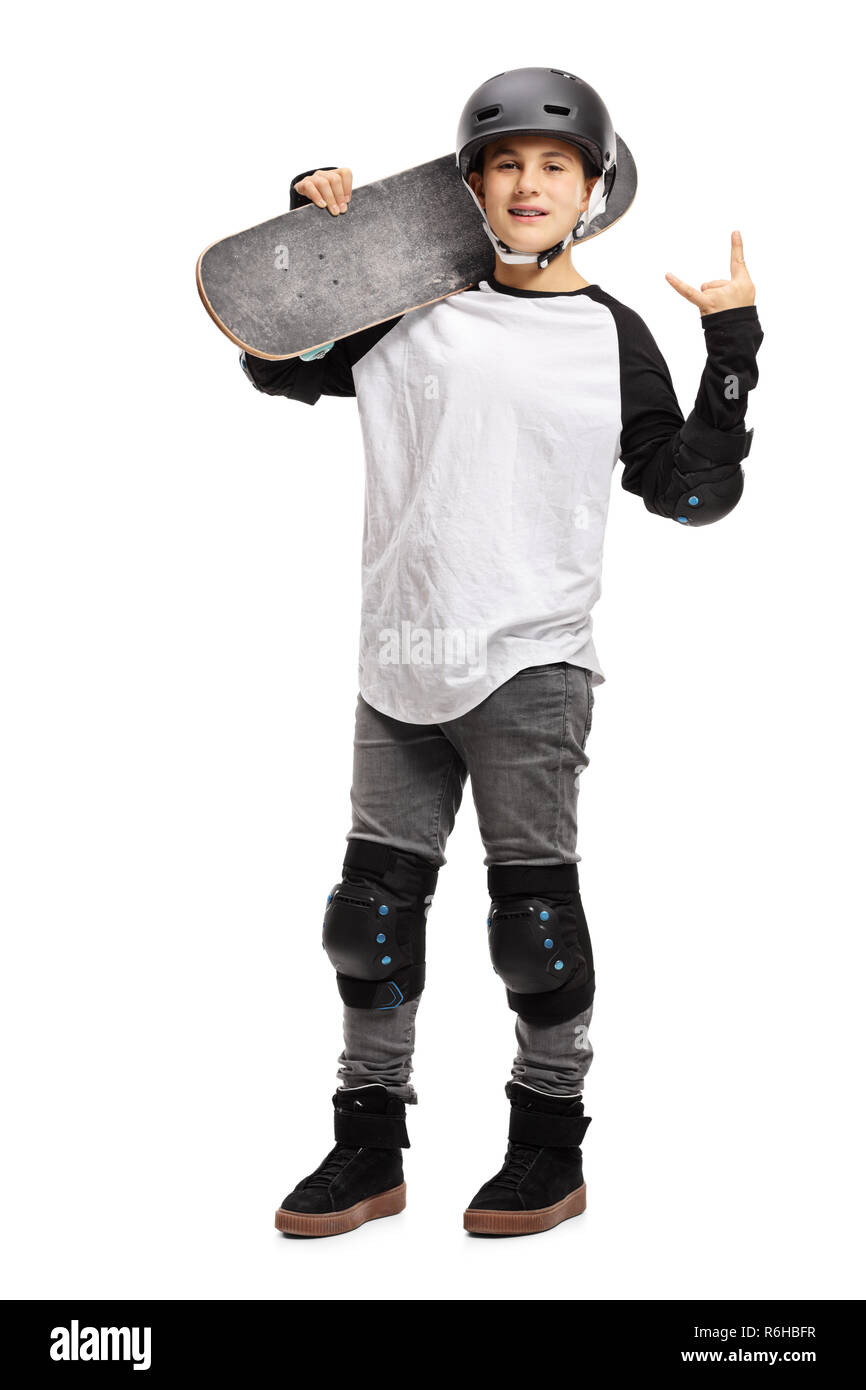 Portrait d'un jeune garçon posant avec une planche à roulettes et gesticulant rock and roll isolé sur fond blanc Banque D'Images