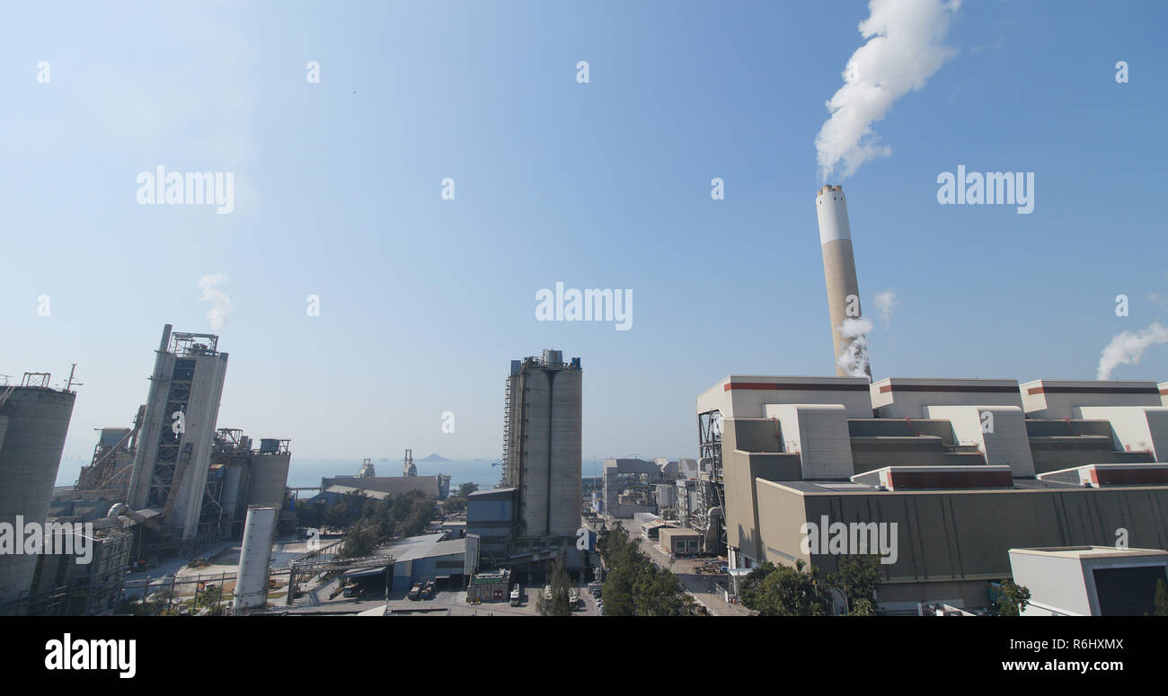 La fumée de cheminée d'usine dans plus de ciel bleu Banque D'Images