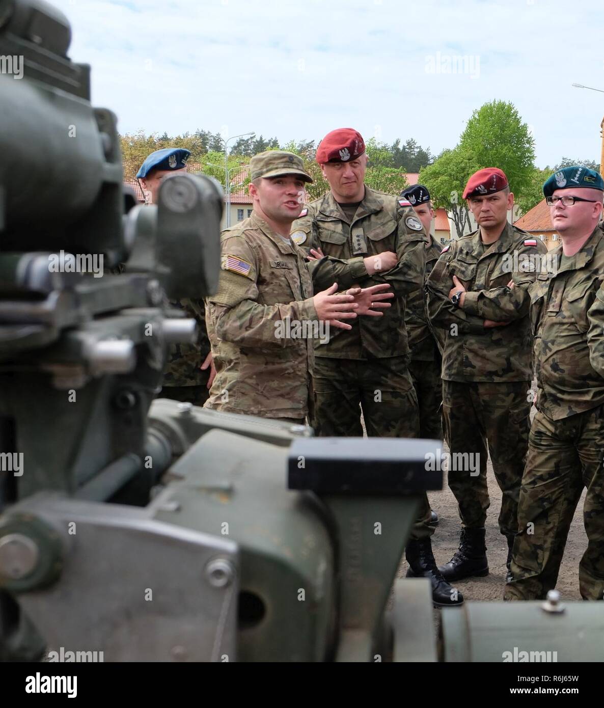 Pologne Groupe bataille soldat américain de la CPS. Piotr Wieslaw Drwal explique aux capitaines des études sur la guerre, l'Université de Varsovie, sur la capacité de l'obusier au cours d'une exposition statique à Bemowo Piskie Zone de formation le 18 mai. Les États-Unis, le Royaume-Uni et les soldats roumains de l'unité multinationale ont été très actif dans l'interaction avec les citoyens pour leur faire prendre conscience de leur présence et d'en apprendre davantage sur la mission du groupe de combat de l'OTAN à l'appui du renforcement de la présence de l'avant. Banque D'Images
