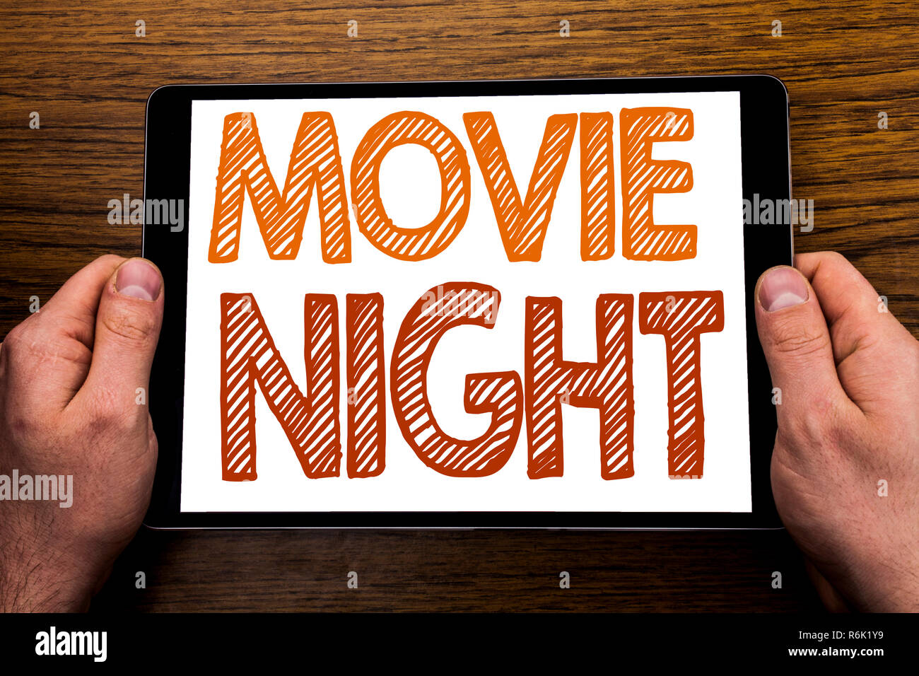 La main légende soirées cinéma. Concept d'affaires pour Wathing Movies écrit sur ordinateur portable, tablette de fond en bois avec businessman main, doigt holding PC. Banque D'Images La main légende soirées cinéma. Concept d'affaires pour Wathing Movies écrit sur ordinateur portable, tablette de fond en bois avec businessman main, doigt holding PC. Banque D'Images