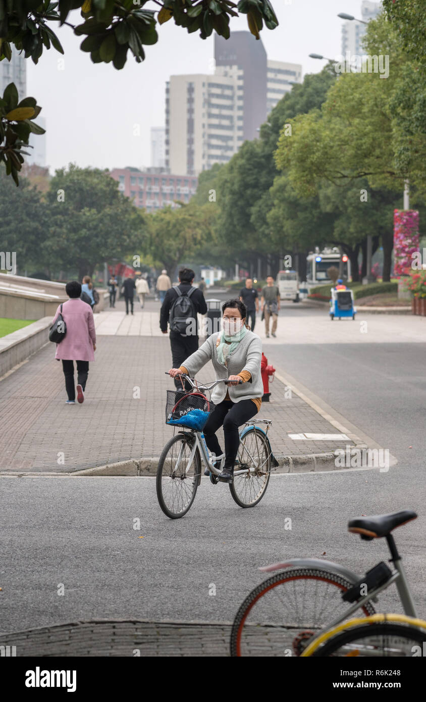 Cycliste à Shanghai avec masque de protection pour la pollution Banque D'Images