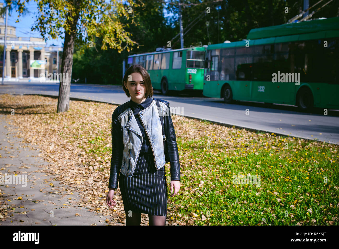Portrait de la rue d'une jeune fille, étudiante à la mode dans les vêtements sombres, avec un sac à dos noir et veste en jean journée ensoleillée d'automne Banque D'Images