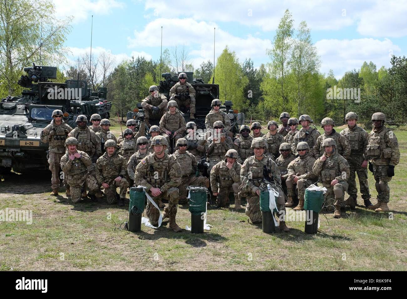 Les soldats du groupement tactique Pologne posent avec quatre cratères frais utilisés pendant la formation de démolition de tir réel près de Bemowo Piskie Domaine de formation, la Pologne, le 10 mai. L'interopérabilité formation a aidé les États-Unis et le Royaume-Uni l'ingénierie groupe de combat des soldats effectuent des missions de démolition dans un environnement mixte. Banque D'Images