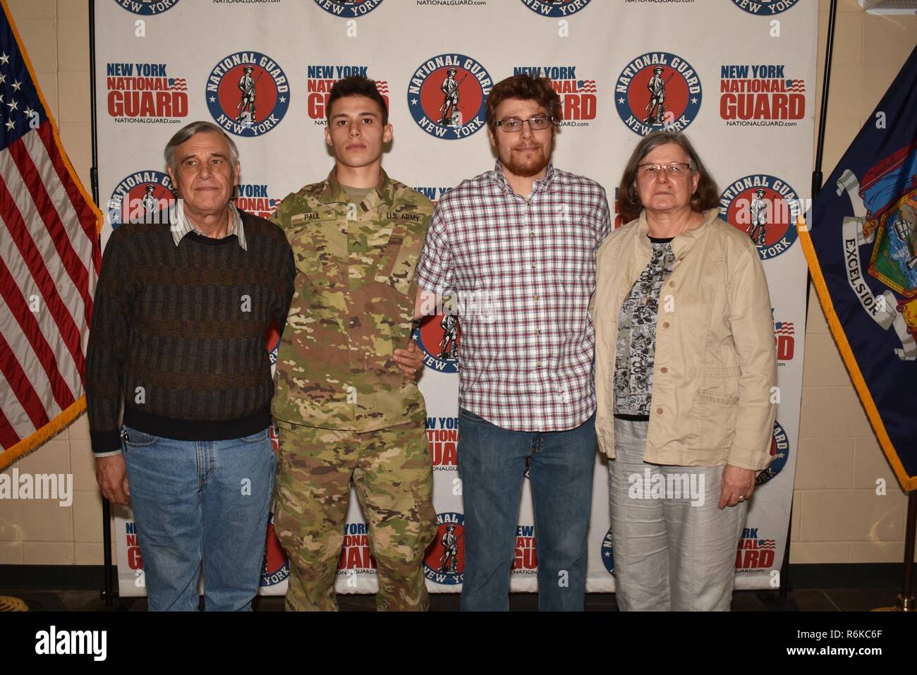 U.S. Army National Guard soldat, Pvt. Paul terrien de la 7e Division des finances, se trouve avec sa famille à l'Armory Queensbury Queensbury, N.Y., 21 mai 2017. Paul avait juste diplômé de la recruter Sustainment Programme avec commande de recrutement et de maintien en poste et a été remis à sa nouvelle unité stationnée dans la ville de New York. Banque D'Images