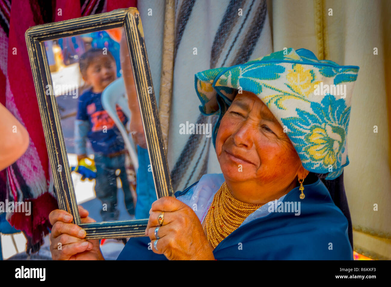 OTAVALO, ÉQUATEUR, 06 novembre 2018 : Close up of Hispanic woman holding autochtones un miroir pour les clients prouver leurs vêtements dans un marché de rue en Ot Banque D'Images