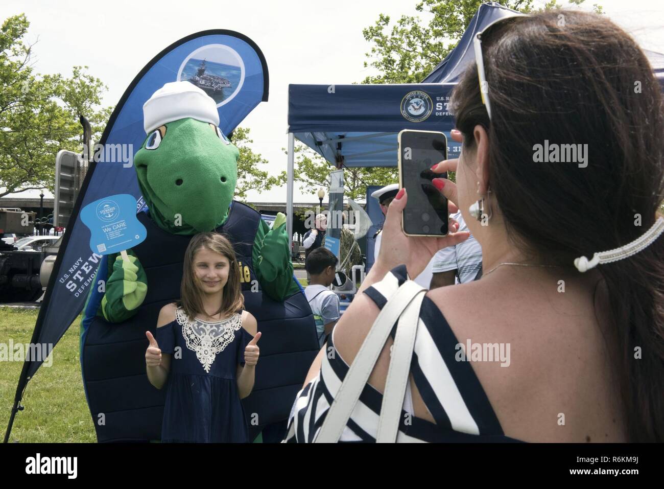 JERSEY CITY, NEW JERSEY. (28 mai 2017), la Marine américaine Stewie's environmental turtle mascot, pose avec les visiteurs du "Gardiens de la mer : défendre la liberté, la protection de l'environnement" la pièce à Liberty State Park au cours de la Fleet Week à New York. La Marine utilise tous les moyens disponibles pour atténuer les effets environnementaux potentiels de nos activités sans compromettre la sécurité de nos marins ou ayant une incidence sur notre mission de préparation de la Marine. Banque D'Images