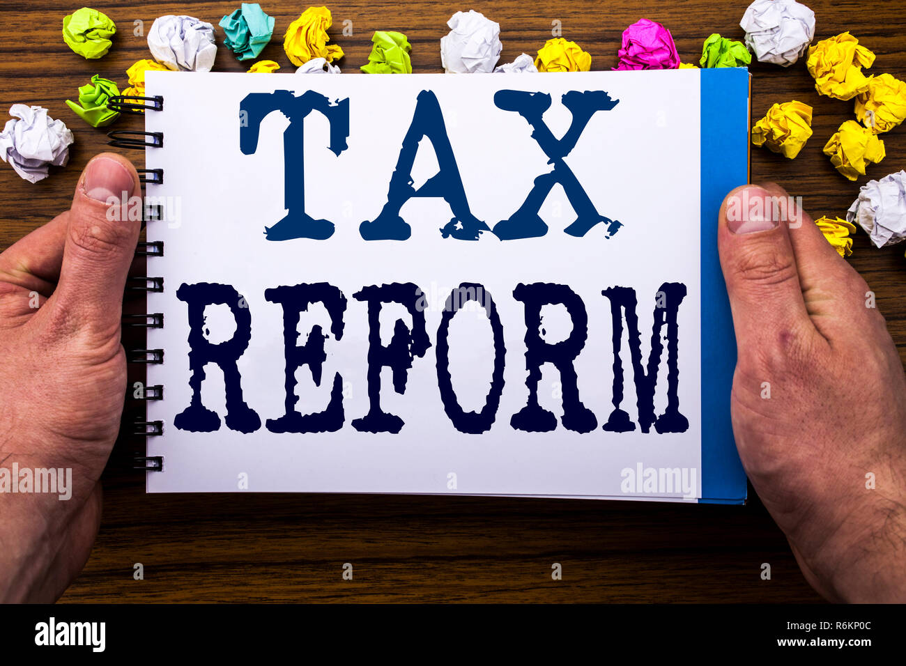 L'écriture de texte montrant la réforme fiscale. Concept d'affaires pour changement de gouvernement en impôts écrit sur notepad notebook livre sur le fond en bois en bois avec l'homme d'affaires main et des doigts. Banque D'Images L'écriture de texte montrant la réforme fiscale. Concept d'affaires pour changement de gouvernement en impôts écrit sur notepad notebook livre sur le fond en bois en bois avec l'homme d'affaires main et des doigts. Banque D'Images