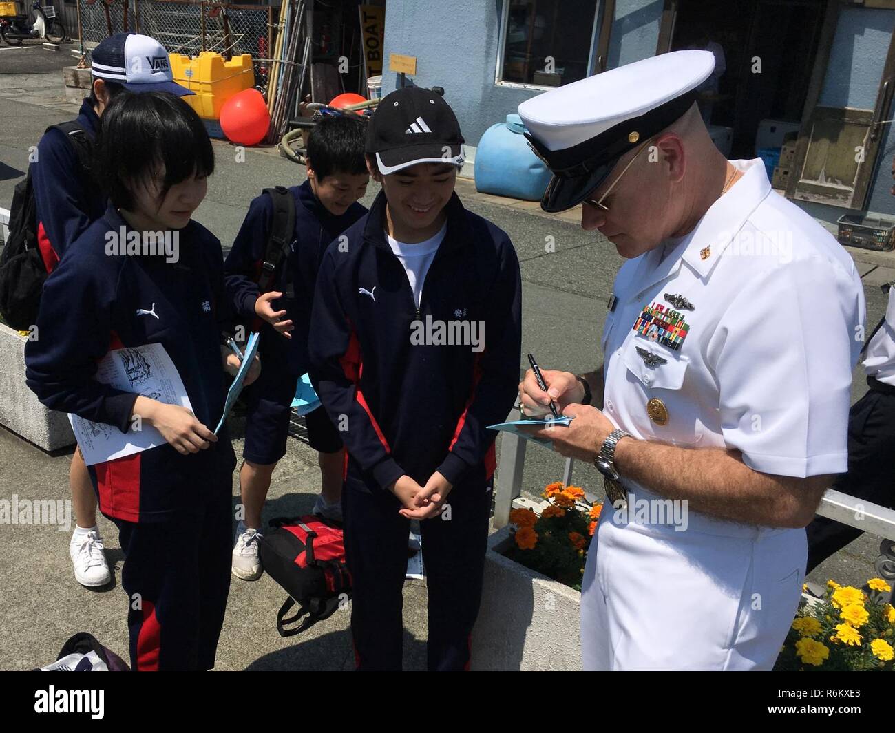 SHIMODA, le Japon (19 mai 2017) - Commande Master Chief Joseph Fahrney, U.S. Naval Forces Japon Japon région marine, signe des autographes pour certains élèves japonais au cours de la première journée du 78e Festival de Bateau Noir Shimoda. La participation de la Marine à ce festival célèbre le patrimoine de la marine japonaise américaine premier partenariat établi par le commodore Matthew Perry's 1853 Visite du port. Banque D'Images