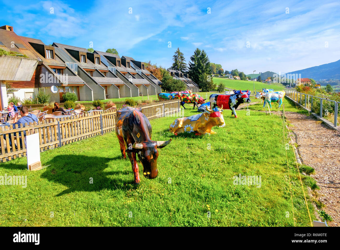 Paysage avec exposition de vaches peintes colorées au Motel de la Gruyère. Gruyère, Suisse Banque D'Images
