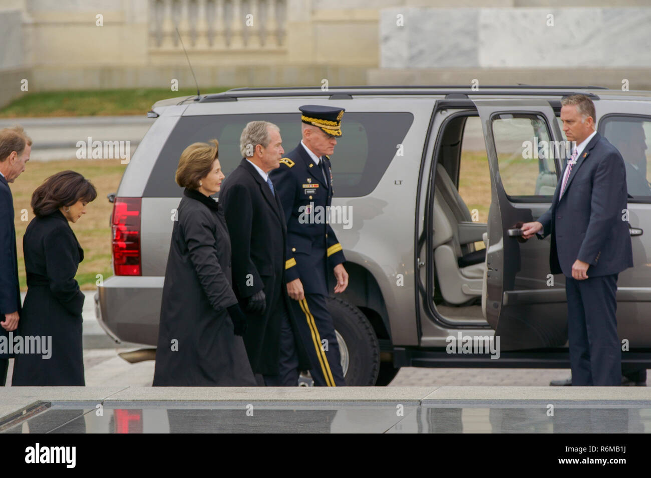 L'ancien président George W. Bush, 43e président des États-Unis et son épouse l'ancienne Première dame Laura Bush, sont accompagnés jusqu'au bas des marches de l'United States Capitol avant le transfert du cercueil de George H. W. Bush, 41e président des États-Unis, de l'United States Capitol à la cathédrale nationale de Washington, Washington, D.C., 5 décembre 2018. Près de 4 000 militaires et civils de partout dans toutes les branches des forces armées américaines, y compris les réserves et les composants de la Garde nationale, à condition que l'appui de cérémonie au cours de George H. W. Bush, le 41e Président de la Banque D'Images