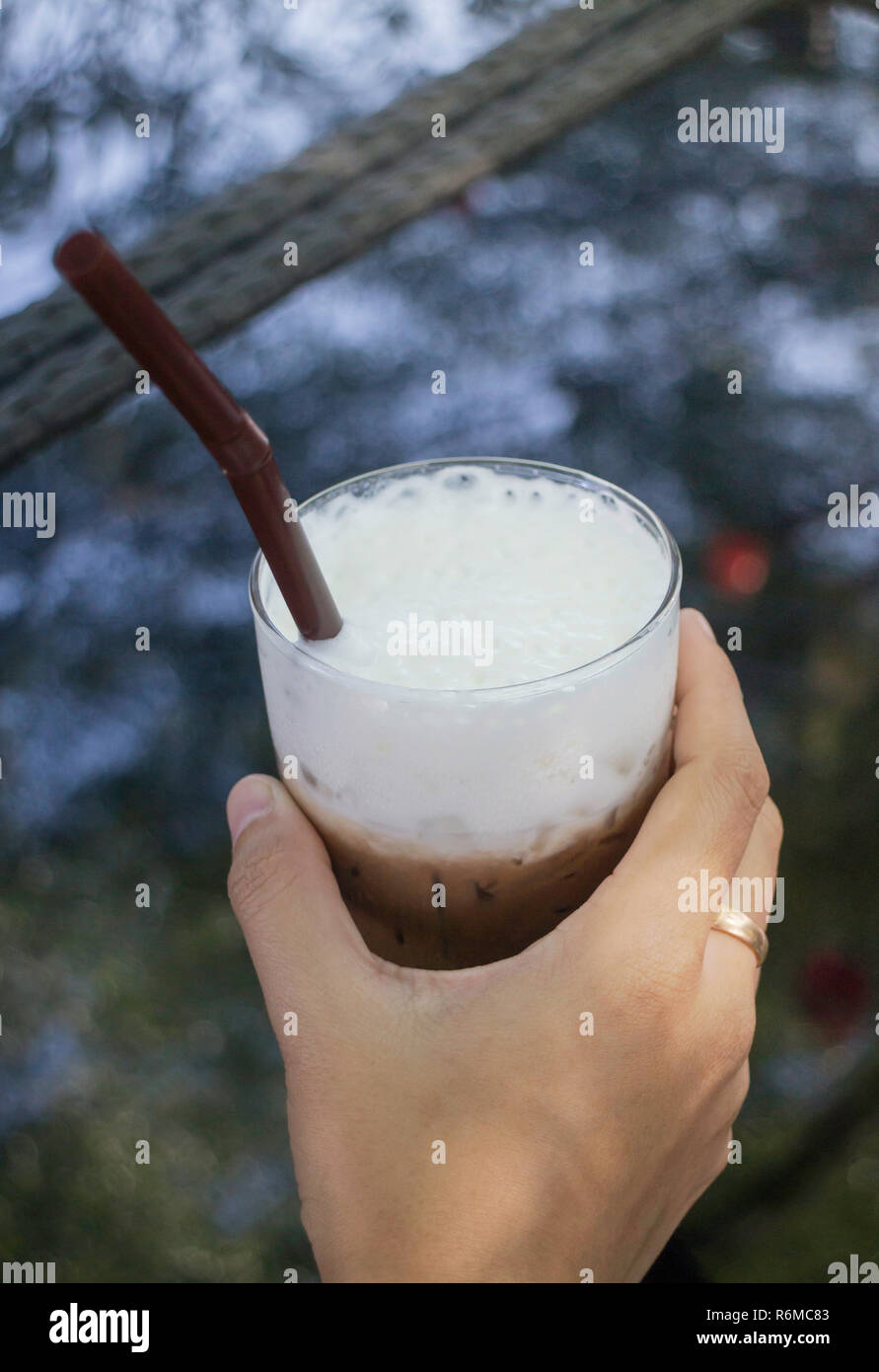 La main sur le verre glacé au chocolat Banque D'Images