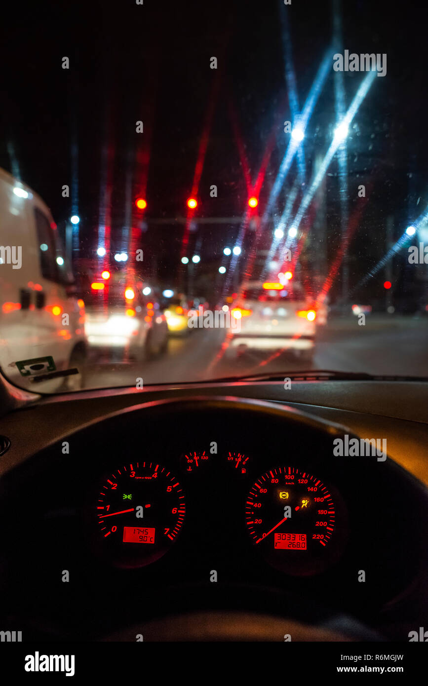 Tableau de bord de voiture et fenêtre la nuit. Feux de circulation Banque D'Images