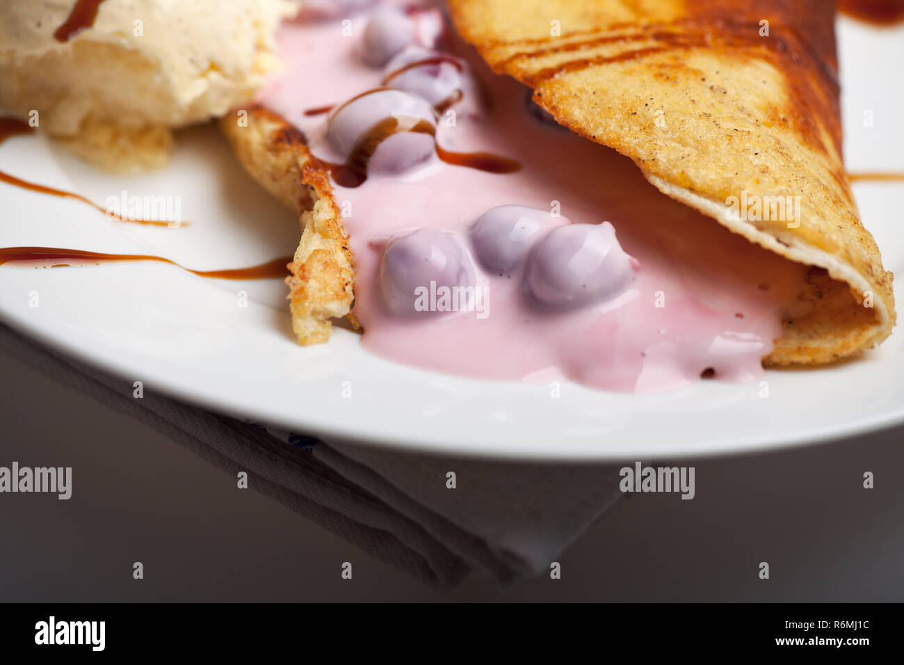 Omelette avec la sauce aux cerises et crème glacée à la vanille Banque D'Images