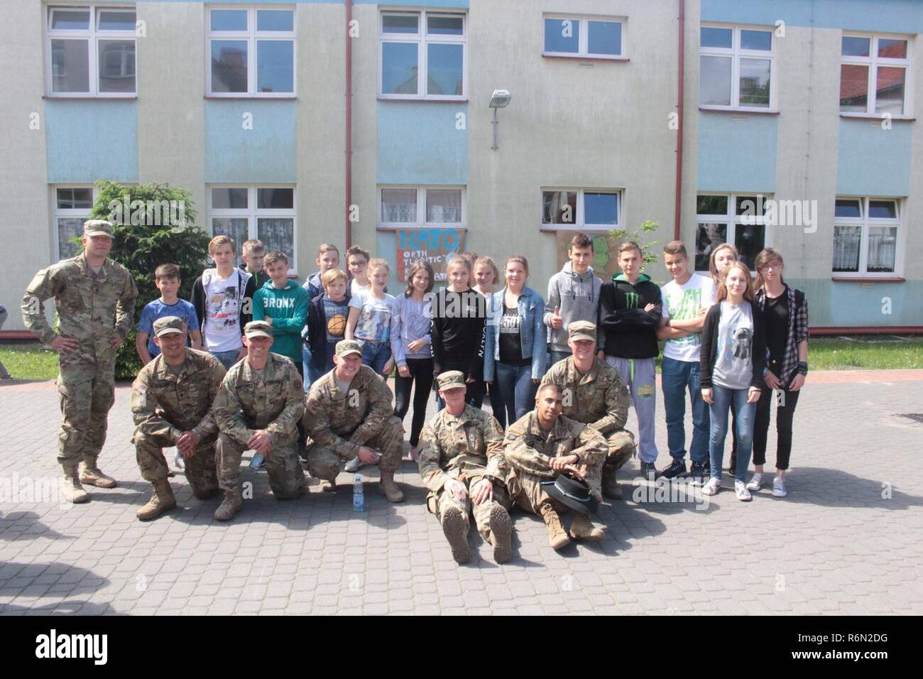 Pologne Groupe de combat des soldats américains posent avec des étudiants d'une école locale de Wydminy, la Pologne au cours de l'OTAN de l'école Jours de l'événement le 30 mai . Le groupement tactique est en Pologne dans le cadre de l'OTAN et de la présence accrue de l'avant les États-Unis, le Royaume-Uni et les soldats roumains de l'unité multinationale ont été très actif avec les communautés voisines tout comme un moyen de rendre les citoyens conscients de leur présence et d'en apprendre davantage sur la mission du groupe de combat. Banque D'Images