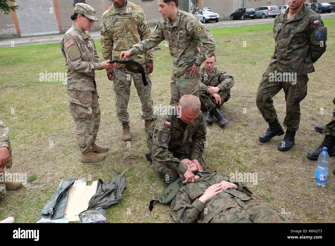 Groupe de combat et la Pologne Polish 15e Brigade mécanisée des soldats apprennent à mettre un collier cervical sur une victime durant la bataille du groupe de combat récent au cours de la vie de Veille Bemowo Piskie Zone d'entraînement. La formation multinationale unique, des États-Unis, du Royaume-Uni et de soldats roumains servir avec la 15e Brigade mécanisée polonaise comme une force de dissuasion dans le nord-est de la Pologne à l'appui de l'OTAN vers l'amélioration de la présence. Banque D'Images