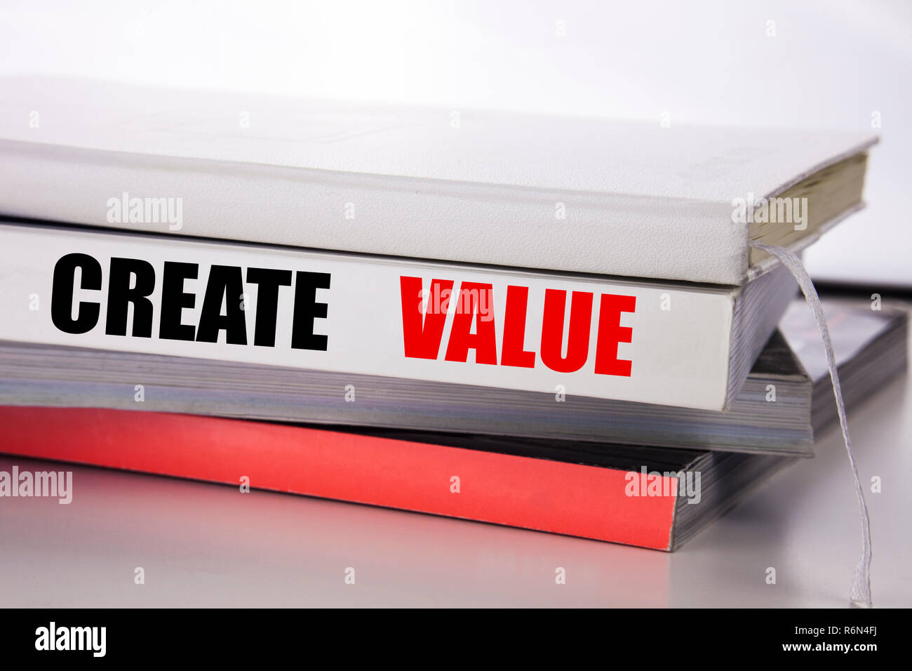 L'écriture de texte montrant la création de valeur. Concept d'affaires pour créer la motivation écrite sur le livre sur le fond blanc. Banque D'Images