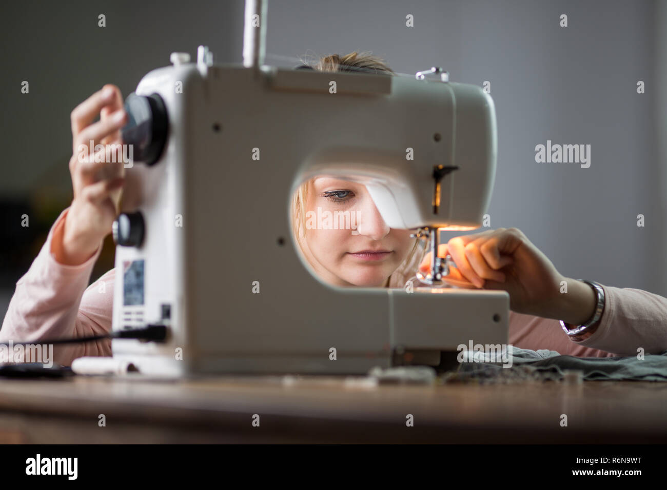 Belle jeune femme vêtements couture avec machine à coudre (tons de couleur peu profondes de l'image 6) Banque D'Images