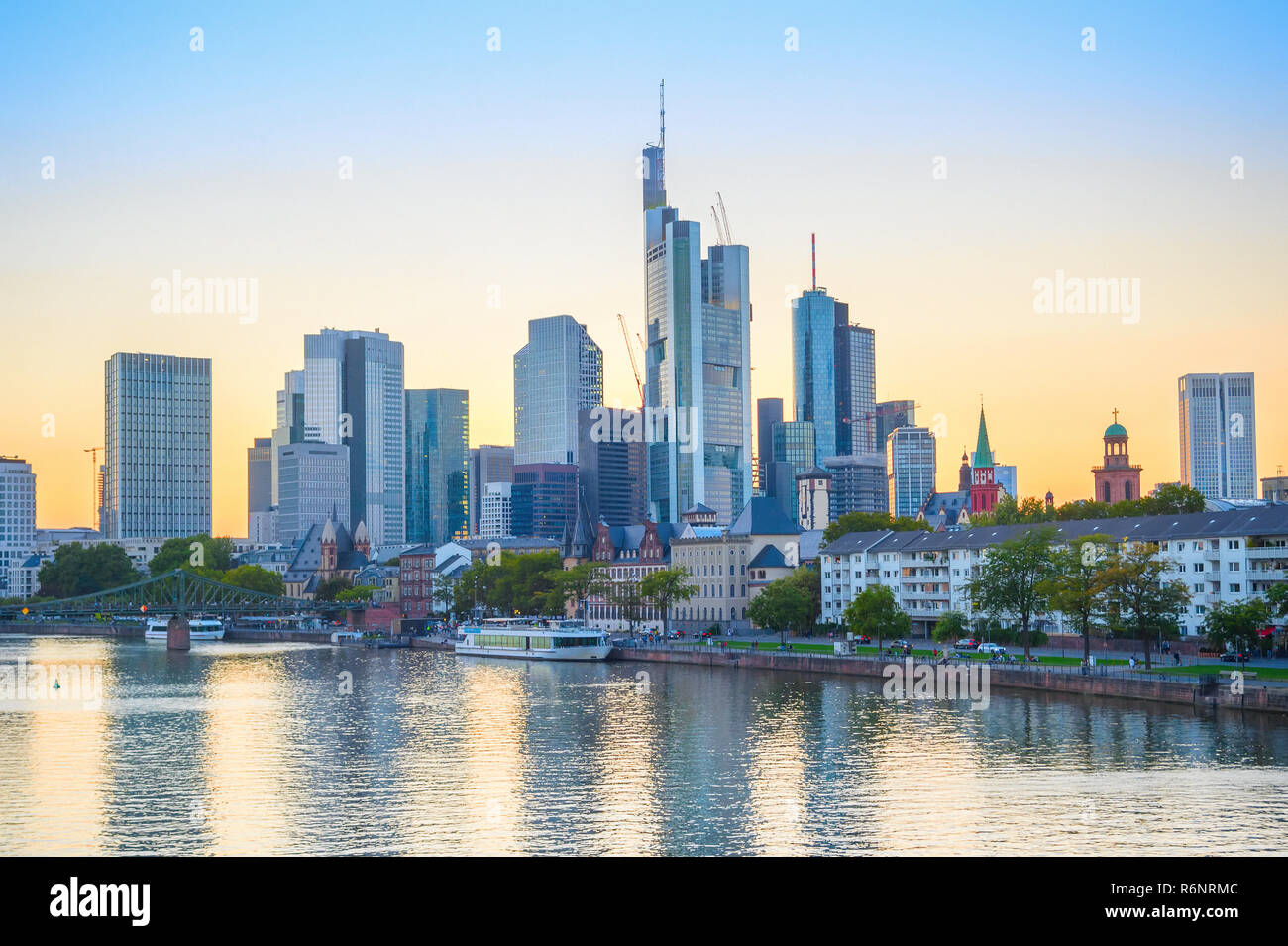 Scène en soirée avec des bateaux touristiques sur River Embankment, ville par ville de l'architecture moderne contre ciel luminescent, Frankfurt am Main, Allemagne Banque D'Images