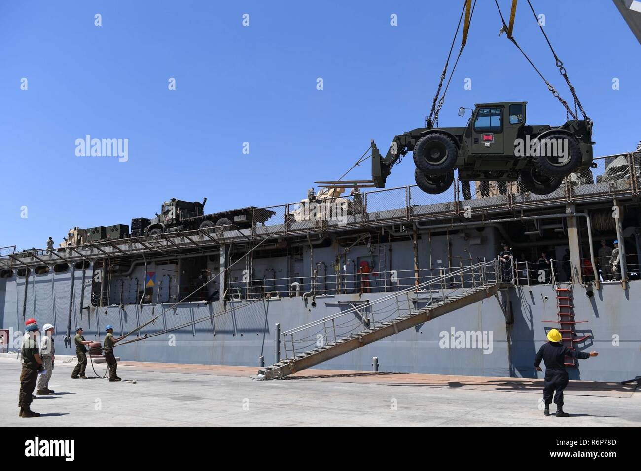 U.S. 5ÈME ZONE DES OPÉRATIONS DE LA FLOTTE (5 mai 2017) marins et Marines à bord du navire de débarquement quai amphibie USS Carter Hall (LSD 50) utilisez l'équipage du navire à grue 30 tonnes de véhicules et d'équipement plus bas sur la jetée à Aqaba, Jordanie, pour faire de l'exercice 2017 lion avide. Lion avide est un exercice annuel le Commandement central américain en Jordanie visant à renforcer les relations militaires entre les Etats-Unis, la Jordanie et d'autres partenaires internationaux. La nouvelle édition se compose d'environ 7 200 militaires provenant de plus de 20 nations qui permettra de répondre aux scénarios impliquant la sécurité des frontières, et de commande Banque D'Images