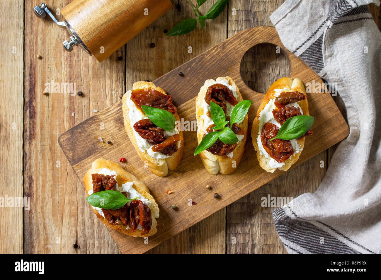 Antipasti italiens des en-cas pour le vin. Brushetta avec fromage doux et tomates séchées sur une table en bois. Banque D'Images