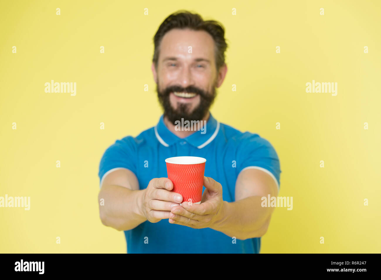 Guy barbe et moustache contient le papier une tasse de thé ou café. Offrir  un verre pour vous. Soins Homme expérimenté formateur sur le bilan  hydrique. Partager et générosité concept. Avoir une