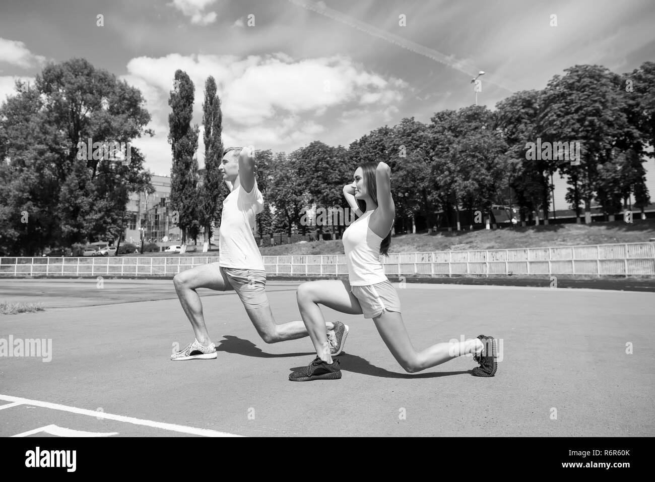 Couple d'entraînement et d'étirement. L'activité d'été et de l'énergie. Coach et de la santé. L'homme et la femme sunny outdoor le ciel bleu. Sport et fitness. Banque D'Images