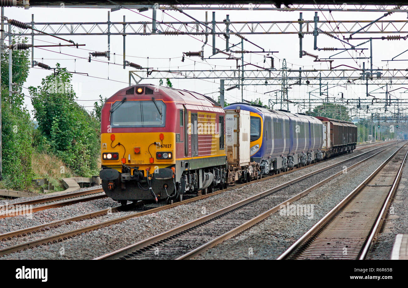 Un certain nombre de locomotives diesel de la classe 67 67027 'Rising Star' barrière de transport de wagons et d'une classe 185 numéro 185116 diesel à Cheddington. Banque D'Images