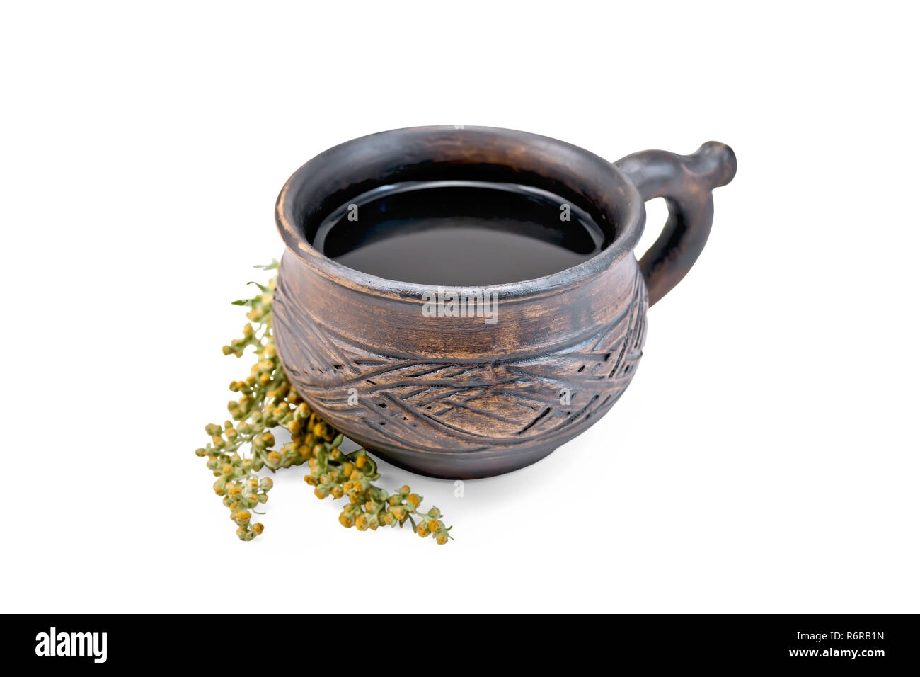 Tisane dans une tasse d'argile brun gris, les brindilles absinthe isolé sur fond blanc Banque D'Images