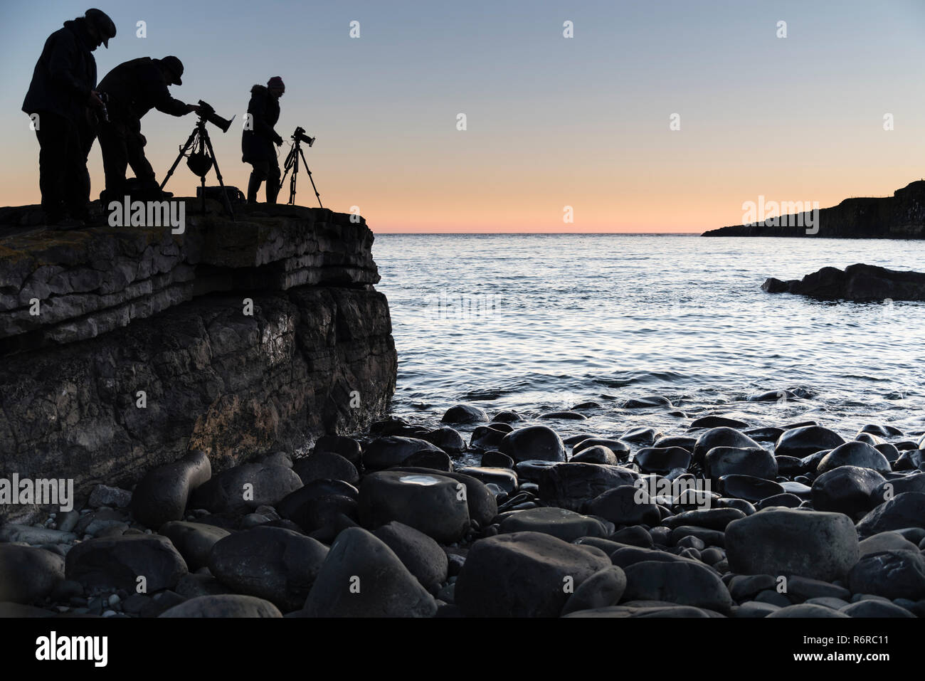 Photographes de la mer contrôle de leurs caméras et découpé sur l'aube. Banque D'Images