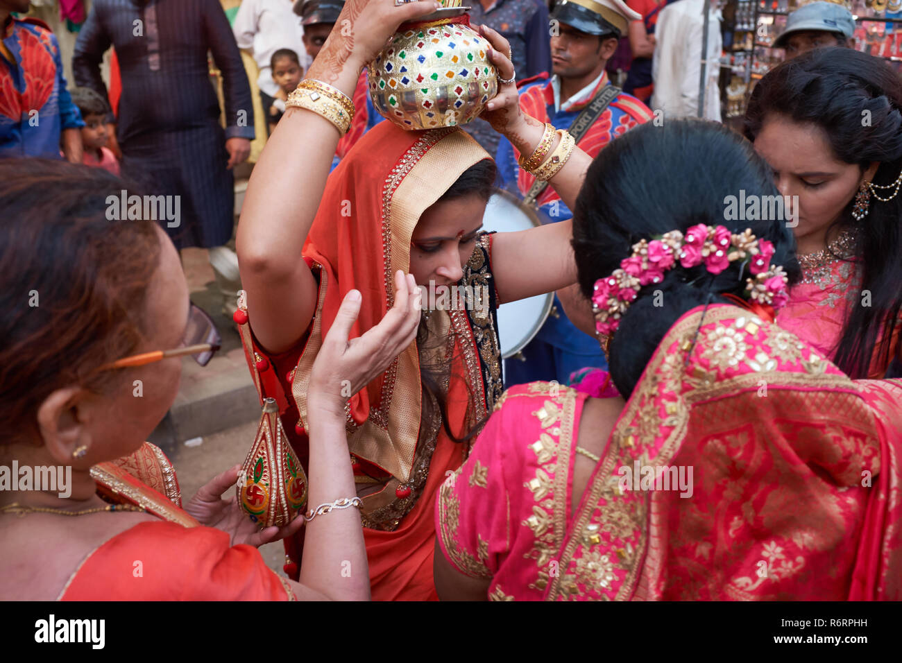 Dans un rituel, une Jain Jain famille accueille un membre de la famille de sexe féminin (portant un navire rituel sur sa tête) retour à l'accueil après une absence, Mumbai, Inde Banque D'Images