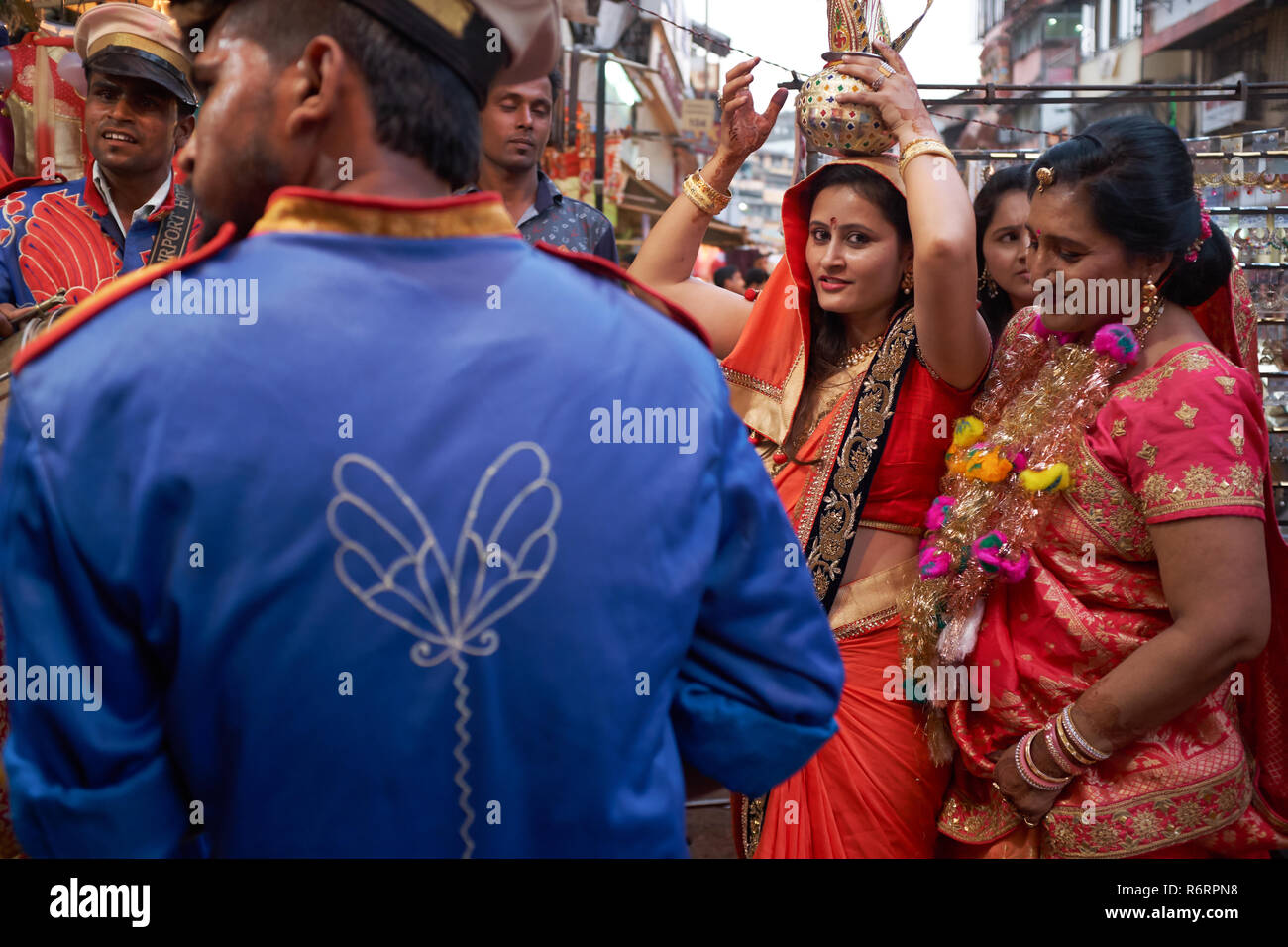Dans un rituel, une Jain Jain famille accueille un membre de la famille de sexe féminin (portant un navire rituel sur sa tête) retour à l'accueil après une absence, Mumbai, Inde Banque D'Images