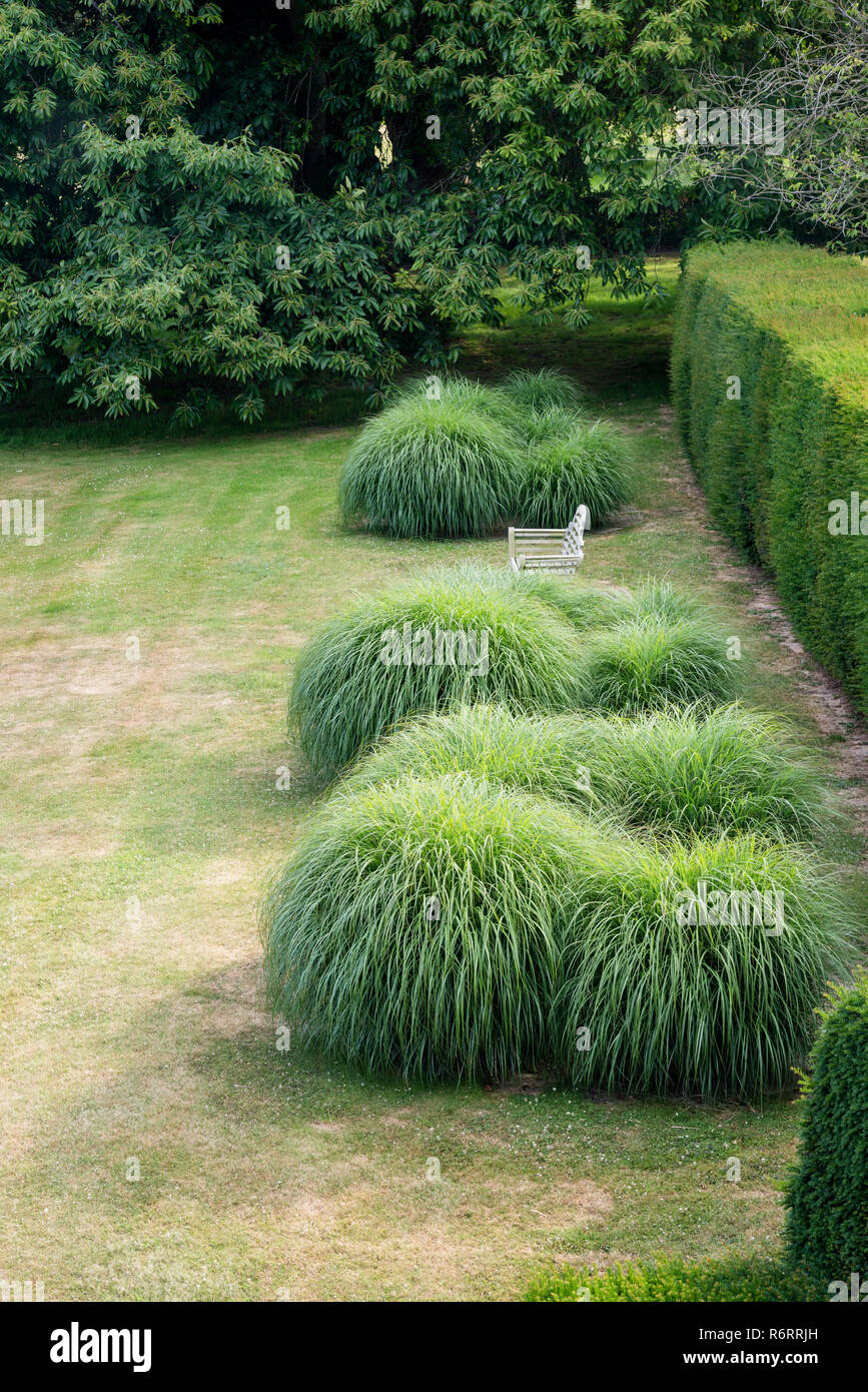 Fauteuil de jardin et des touffes de graminées ornementales en 18e siècle Goodnestone estate Banque D'Images